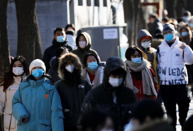 Люди в масках на аллее Нанлуогусян в Пекине, Китай (иллюстрация – фото REUTERS, автор Tingshu Wang)